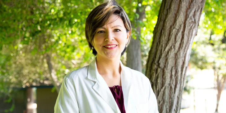 A dentist standing under a tree.