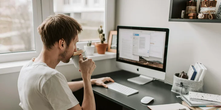 A man drinking coffee while working.