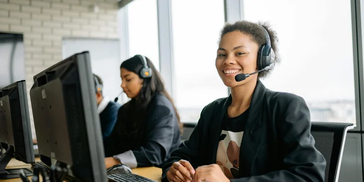 A smiling woman sitting at her work station.