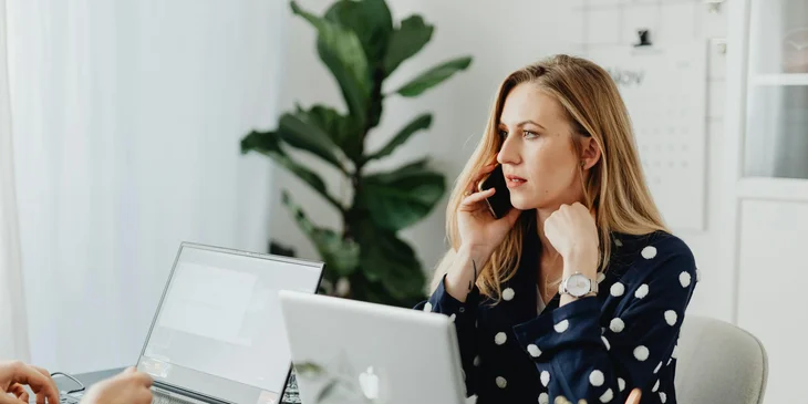 An administrative assistant making appointments via call.