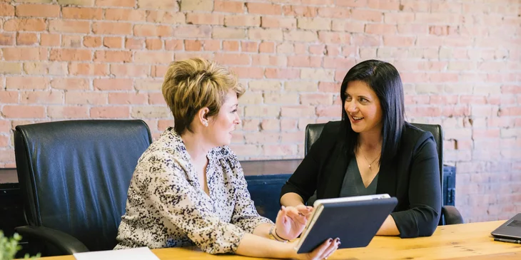 An administrative associate training a new office administrator.