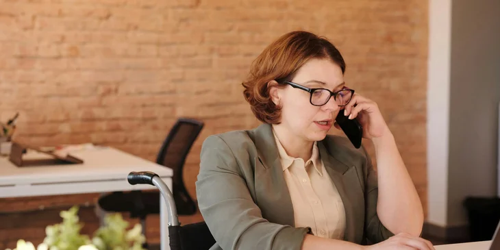 An admissions coordinator answering the potential client's questions via phone call.