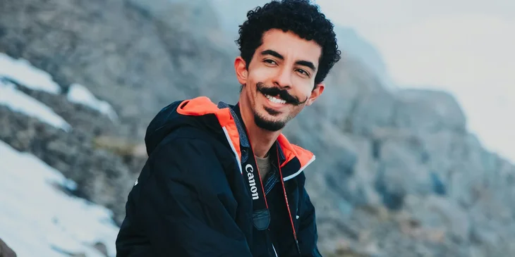 A traveler sitting on a hilltop.