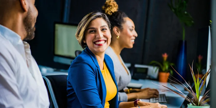 A woman smiling at a coworker.