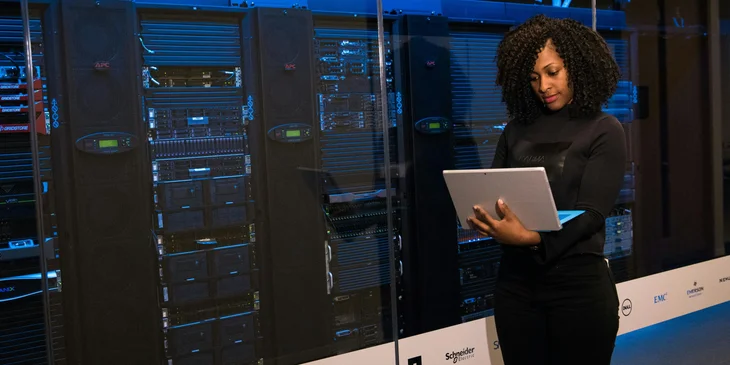 A software engineer standing beside the server racks.