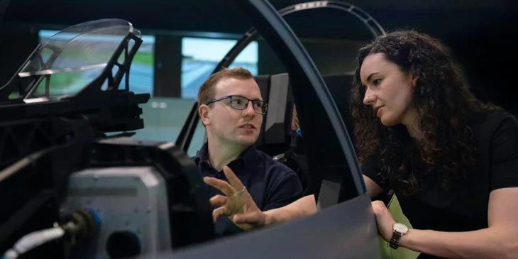 A female aerospace engineer setting her colleague's expectations regarding the flight simulator pod.