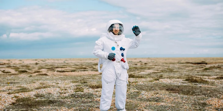 An astronaut waving his hand.