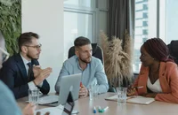 Un grupo de empleados del departamento de Recursos Humanos comentan el análisis de un empleo