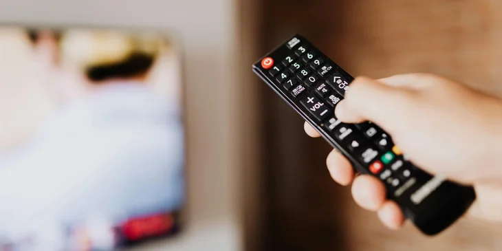 A hand gripping a remote control.
