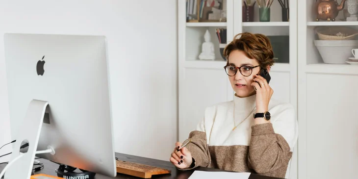 An appointment setter talking with a client on the phone offering the company's services.
