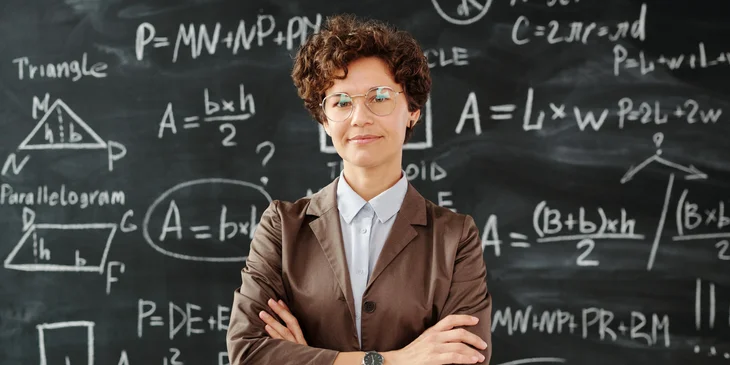 A woman standing in front of a blackboard.