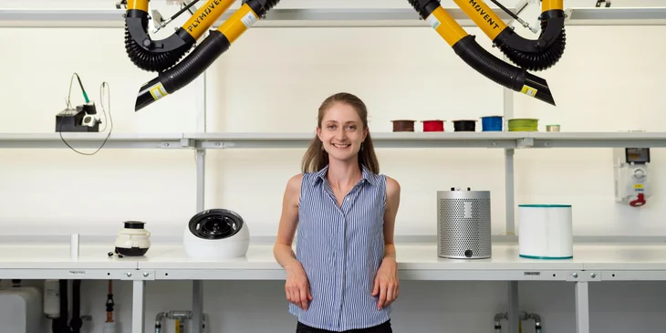 A woman standing near an advanced engineering technology.