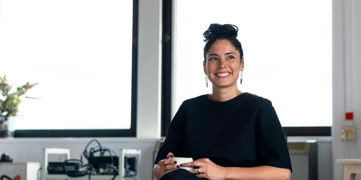 A smiling woman sitting on a chair.
