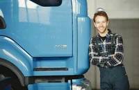 Ein Angestellter lehnt sich an einen Lastkraftwagen an.