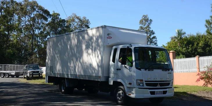 A driver navigating a delivery truck to transport goods across the border on a sunny day.