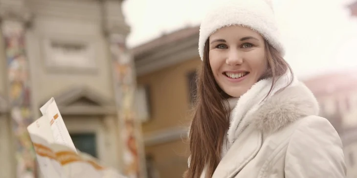 A smiling woman holding a map.