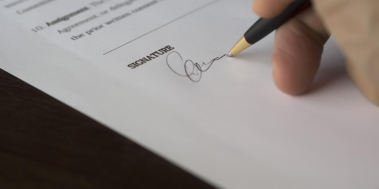 A person signing a background check authorization form.