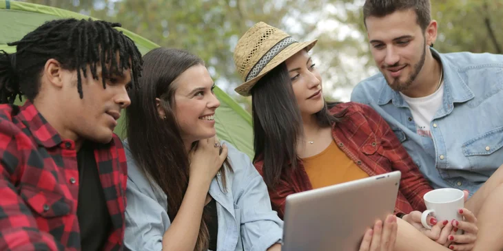 A group of people surfing a tablet.