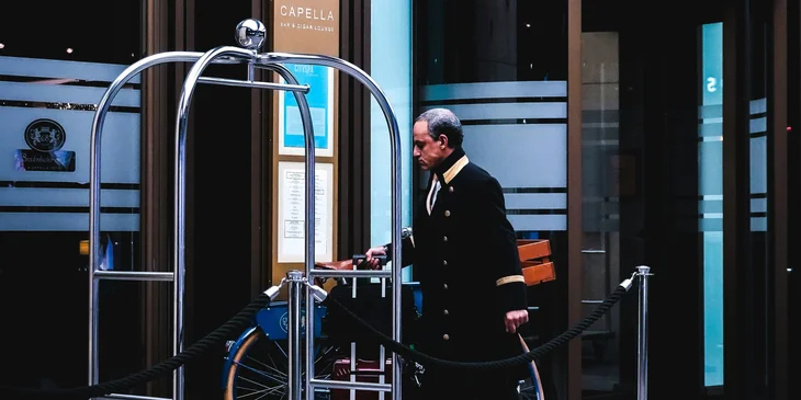 A baggage porter attending to luggage to place it on a trolley.