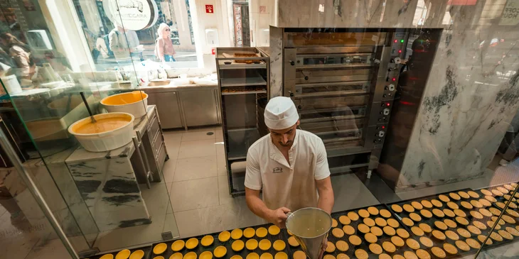 A baker preparing pastel de nata.