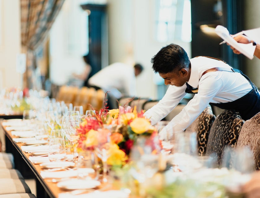 A banquet server prepares a banquet table