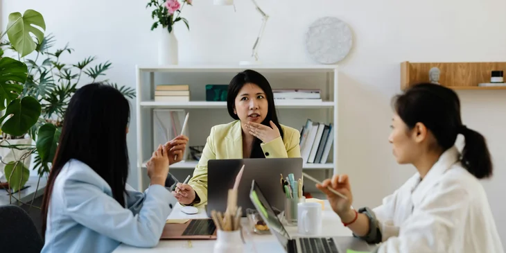 Three women collaborating on a marketing plan.