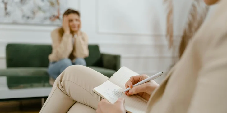 A behavior analyst observing the client's behavior and writing it in her notebook.