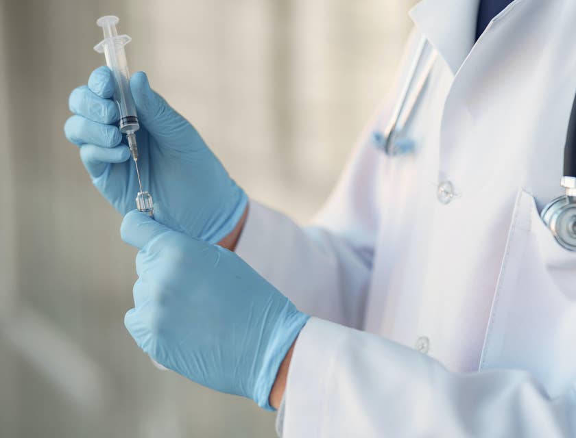A healthcare professional preparing a syringe.