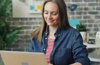 Masa başında laptop kullanan bir kadın.