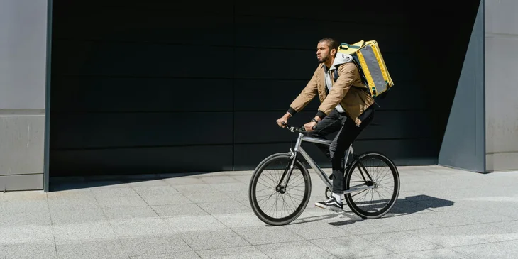 A bike courier delivering a parcel to a client.