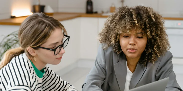 Two women brainstorming at a meeting.