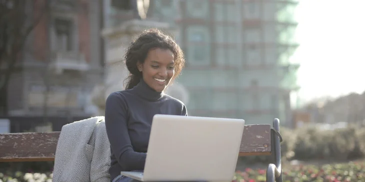 A woman using her laptop outdoors.