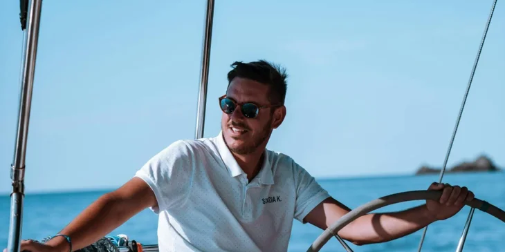 A maritime professional steering a boat.