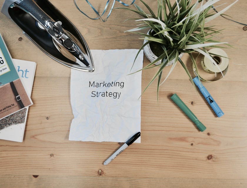 Una hoja de papel con la frase “Estrategia de marketing”, escrita en inglés, en una bolsa de trabajo para marketing.