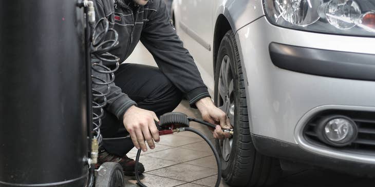 Un técnico automotriz realizando tareas en un automóvil.