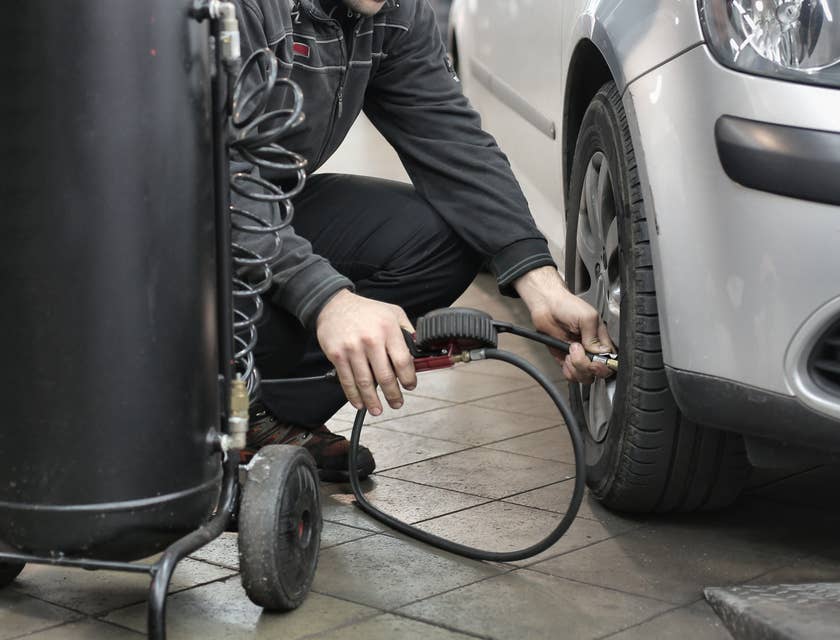 Un técnico automotriz realizando tareas en un automóvil.