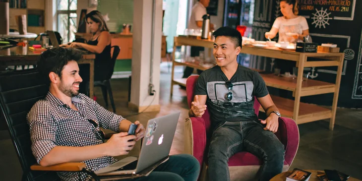 Two people having a conversation in a work office.