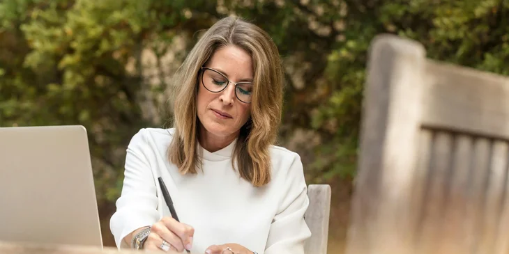 A woman writing on a notepad.