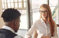 Una mujer reclutadora hablando sobre cómo prepararse para una entrevista de trabajo.