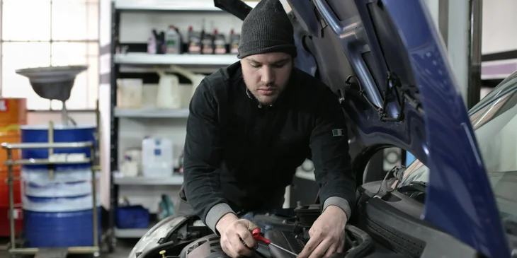A man fixing a car part.