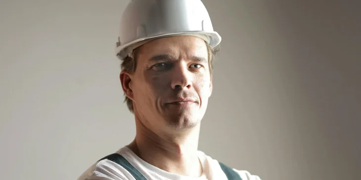 A constructor wearing a helmet and uniform.