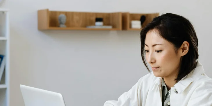 A woman looking at her laptop.