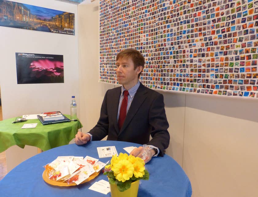 A business professional sitting at table at a career fair.
