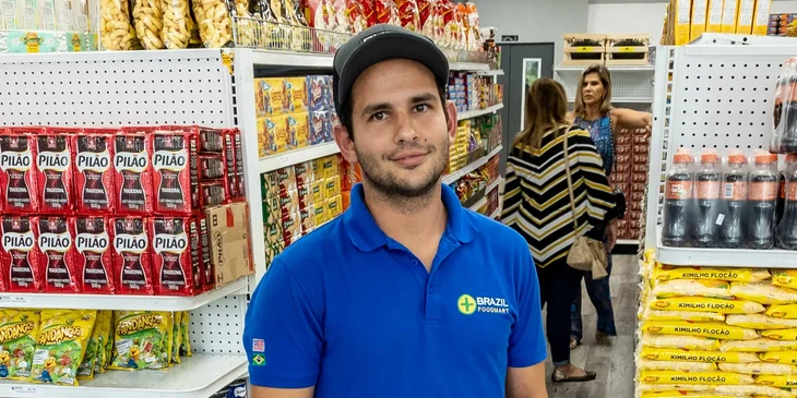 A man wearing a blue polo shirt at a grocery store.