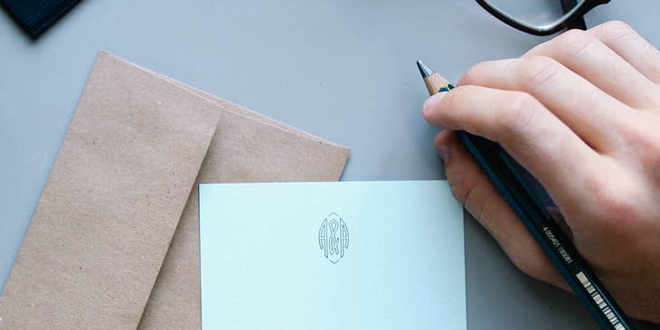 Un jefe escribiendo una carta de agradecimiento profesional para sus empleados más destacados.