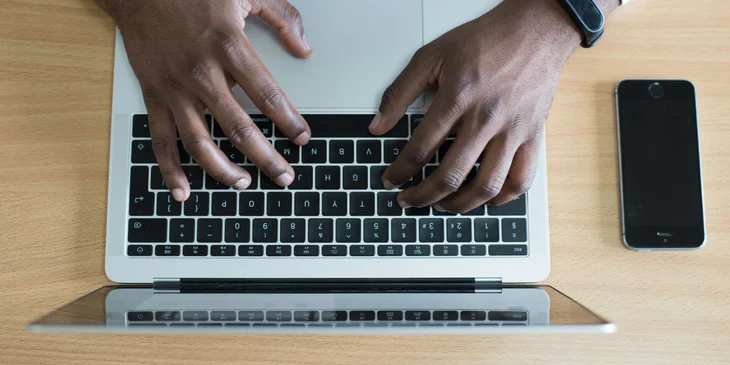 Una persona que escribe una carta de preaviso de dos semanas en su computadora.