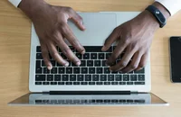 Una persona que escribe una carta de preaviso de dos semanas en su computadora.