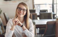 Una editora sentada detrás de su escritorio, mientras escribe una carta de presentación.