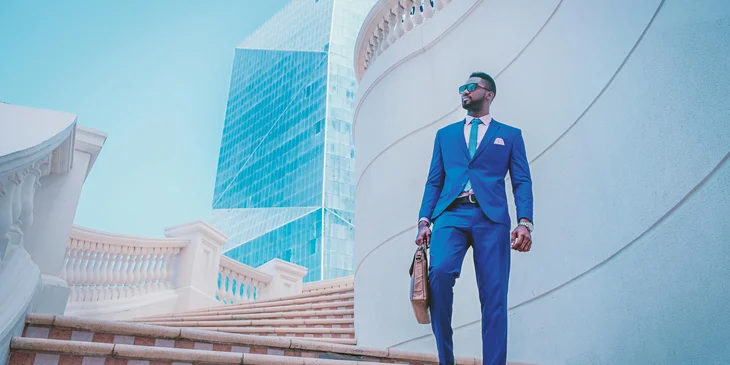 A man in a blue suit walking down the stairs.