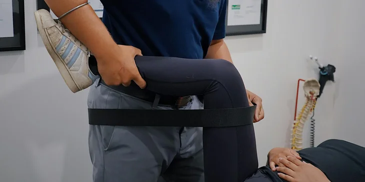 A physiotherapist working with a patient's leg.